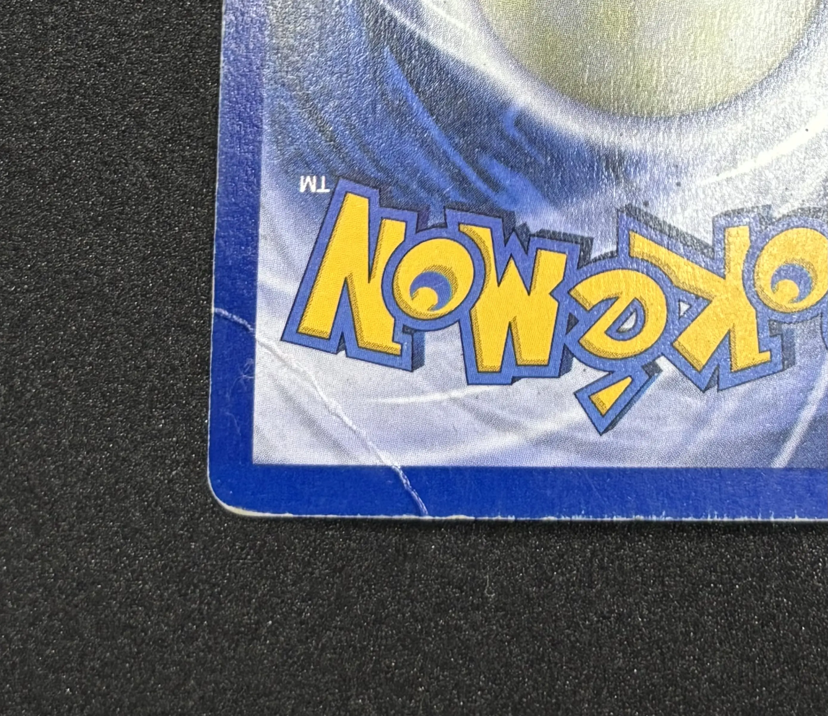 Pokemon card before restoration - visible crease and edge wear